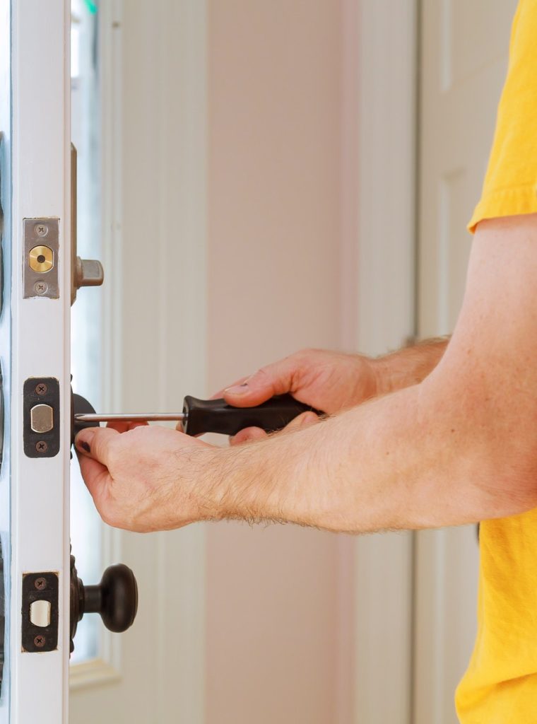 Worker installing or repairing new lock handyman repair the door lock